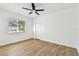 Bright, minimalist bedroom with a ceiling fan and natural light from the window at 6314 Soratrace St, Lithia, FL 33547