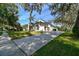 A beautiful home's side view with a spacious driveway and landscaped front yard with mature trees on a sunny day at 6314 Soratrace St, Lithia, FL 33547