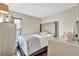 Cozy bedroom with hardwood floors, a tufted headboard, and soft lighting for a relaxing atmosphere at 6843 Se Dartmouth Hill St, Riverview, FL 33578