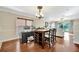 Bright dining area featuring hardwood floors, a modern chandelier, and a functional workspace with a computer setup at 6843 Se Dartmouth Hill St, Riverview, FL 33578