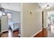 Hallway with wood floors leading to a bedroom; thermostat is visible at 6843 Se Dartmouth Hill St, Riverview, FL 33578