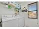 This laundry room includes a washer, a dryer, a window, and wall storage at 6843 Se Dartmouth Hill St, Riverview, FL 33578