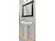 Modern powder room featuring a pedestal sink, framed mirror, and contemporary fixtures at 6843 Se Dartmouth Hill St, Riverview, FL 33578