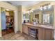 Well-lit primary bathroom showcasing double sinks and ample storage space, with a peek into the walk-in closet at 716 Burlwood St, Brandon, FL 33511