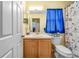Cozy bathroom with a single sink, wood cabinets, and a nautical-themed shower curtain for a fresh look at 716 Burlwood St, Brandon, FL 33511