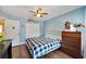 Bright bedroom featuring wood floors, a ceiling fan, and a television atop a chest of drawers at 716 Burlwood St, Brandon, FL 33511
