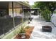 Cozy screened patio featuring an outdoor grill, dining, and tranquil water view at 716 Burlwood St, Brandon, FL 33511