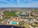 Aerial view of a community clubhouse, golf course, pool, and surrounding neighborhood at 720 Chipper Dr, Sun City Center, FL 33573