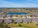 Aerial view of a community with a picturesque lake surrounded by well-manicured lawns at 720 Chipper Dr, Sun City Center, FL 33573