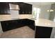 Stylish kitchen featuring black cabinets, quartz countertops, and modern fixtures at 740 Steel Dr, Apollo Beach, FL 33572