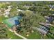 Aerial view highlighting tennis courts and clubhouse nestled among lush trees and beautiful community landscaping at 8130 Braddock Cir # 3, Port Richey, FL 34668