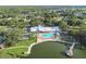 Gorgeous aerial view of a community clubhouse with a swimming pool, lake, and surrounding lush landscaping at 8130 Braddock Cir # 3, Port Richey, FL 34668
