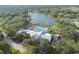 Overhead shot featuring the clubhouse, pool, and lake surrounded by mature trees at 8130 Braddock Cir # 3, Port Richey, FL 34668