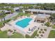 Community pool with a shaded lounge area, tables, chairs, and lush landscaping at 8130 Braddock Cir # 3, Port Richey, FL 34668