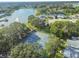 Scenic aerial view featuring community tennis courts nestled near a tranquil lake with fountain and lush landscaping at 8130 Braddock Cir # 3, Port Richey, FL 34668