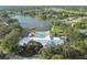 Aerial view of the clubhouse and pool, with a scenic lake backdrop and ample green space at 8130 Braddock Cir # 3, Port Richey, FL 34668