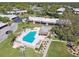 Community pool with a shaded lounge area, tables, chairs, and lush landscaping at 8130 Braddock Cir # 3, Port Richey, FL 34668
