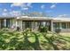A sunny view of the backyard with shade trees, and the home's patio at 8130 Braddock Cir # 3, Port Richey, FL 34668