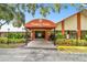 Clubhouse entrance featuring covered awning, professionally landscaped foliage, and ample parking at 8130 Braddock Cir # 3, Port Richey, FL 34668