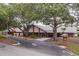 Inviting exterior view of a community clubhouse with mature trees, manicured lawns, and ample parking at 8130 Braddock Cir # 3, Port Richey, FL 34668
