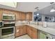 Well-lit kitchen featuring stainless steel appliances, wood cabinetry, and granite countertops at 8130 Braddock Cir # 3, Port Richey, FL 34668