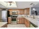 Bright kitchen featuring wooden cabinetry, stainless steel appliances, and granite countertops at 8130 Braddock Cir # 3, Port Richey, FL 34668