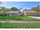 Single Gathering home boasting a manicured lawn, neutral paint, rock columns, and attached two car garage at 864 Pinewood W Ter, Palm Harbor, FL 34683