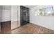 Bedroom with mirrored closet doors, wood-look flooring, and ample sunlight from the window at 10453 Carrollbrook Cir # 122, Tampa, FL 33618