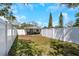 Backyard features a white privacy fence, grass and the back of the home at 1076 Philippe Pkwy, Safety Harbor, FL 34695