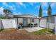 Outdoor patio with seating area, grill, blue door, and white fence provides a relaxing space at 1076 Philippe Pkwy, Safety Harbor, FL 34695