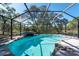 Beautiful screened-in pool with rock waterfall feature, perfect for hot summer days at 11414 Palomar St, Spring Hill, FL 34609