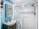 Updated bathroom featuring a glass enclosed shower, a sink and vanity, and bright blue walls at 1348 Chesterfield Dr, Clearwater, FL 33756