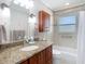 Bathroom featuring a vanity with granite countertop and tub with tile surround and shower at 1348 Chesterfield Dr, Clearwater, FL 33756