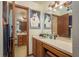 Functional bathroom featuring a vanity, sink, mirror and a doorway leading to a combined shower and tub at 1888 Springbush Ln, Clearwater, FL 33763