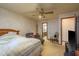 Well lit bedroom with a ceiling fan, doorway to a full bathroom and comfortable furniture at 1888 Springbush Ln, Clearwater, FL 33763