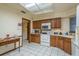 Functional kitchen with wooden cabinets, white appliances, and a bright overhead light at 1888 Springbush Ln, Clearwater, FL 33763