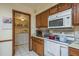 Kitchen with wooden cabinets, white appliances and pass-through to the laundry room at 1888 Springbush Ln, Clearwater, FL 33763