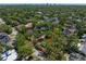 Aerial view pointing to the property, surrounded by mature trees in a residential neighborhood, cityscape in the distance at 203 S Coolidge Ave, Tampa, FL 33609