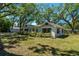 Charming home exterior with green shutters, lush landscaping, and shade trees at 203 S Coolidge Ave, Tampa, FL 33609
