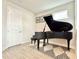 A cozy living room showcasing a black piano, complemented by a stylish rug and light wood floors at 208 S Tampania Ave # 4, Tampa, FL 33609