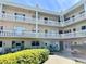Charming condo exterior with balconies, colorful doors, lush landscaping, and inviting seating areas at 2331 Finlandia Ln # 43, Clearwater, FL 33763