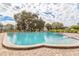 Large pool surrounded by chairs and greenery on a sunny day at 2331 Finlandia Ln # 43, Clearwater, FL 33763