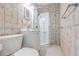 Bathroom features decorative tiled walls, toilet, vanity, and shower with glass doors at 2412 53Rd S St, Gulfport, FL 33707