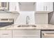 Kitchen highlighting white cabinets, granite counters, stainless steel appliances, and hexagon backsplash at 2412 53Rd S St, Gulfport, FL 33707