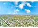 Expansive aerial view of a lush, established neighborhood with mature trees, a serene lake, and distant ocean vistas at 2507 Royal Pines Cir # 2H, Clearwater, FL 33763