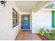 Inviting entryway with a decorative welcome sign, tiled floor, and verdant landscaping at 2507 Royal Pines Cir # 2H, Clearwater, FL 33763