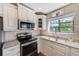 Lovely kitchen with granite countertops, stainless steel appliances, and bright window at 2507 Royal Pines Cir # 2H, Clearwater, FL 33763
