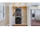 Convenient laundry room closet with stacked washer and dryer and wire shelving for storage at 2507 Royal Pines Cir # 2H, Clearwater, FL 33763