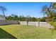 Spacious backyard featuring a well-maintained lawn and a decorative stone privacy fence at 2612 Leafwing Ct, Palm Harbor, FL 34683