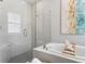 Bright bathroom features a tub with elegant tile surround, and a separate glass-enclosed shower at 2612 Leafwing Ct, Palm Harbor, FL 34683